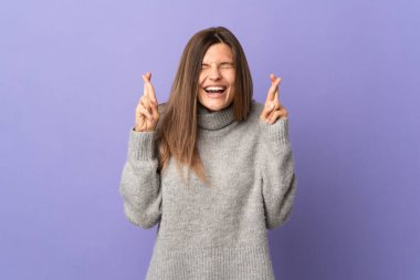 Genç Slovak kadın mor arka planda izole edilmiş ve parmakları çapraz