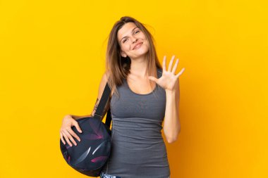 Sarı arka planda izole edilmiş spor çantalı Slovak kadın parmaklarıyla beşi sayıyor.