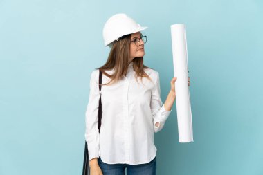 Slovak mimar kız elinde mavi arka planda izole edilmiş planlar tutuyor.