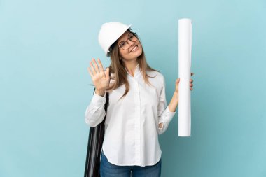 Slovak mimar kız elinde mavi arka planda izole planlar tutarken mutlu bir ifadeyle selam veriyor.