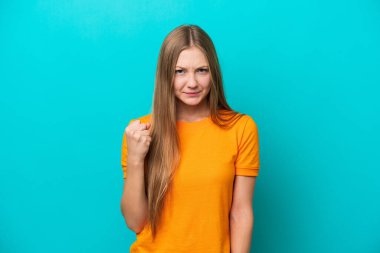 Genç Rus kadın mutsuz bir ifadeyle mavi arka planda izole edilmiş.