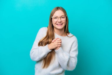 Genç Rus kadın mavi arka planda yalnız gülüyor.