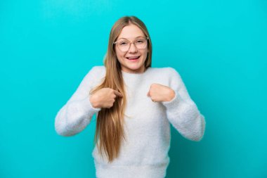 Mavi arka planda yalıtılmış genç bir Rus kadın. Şaşırtıcı bir yüz ifadesi var.