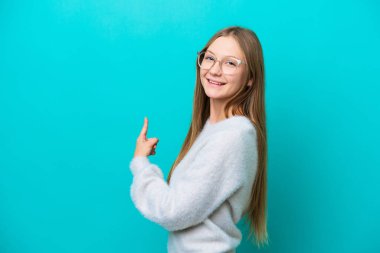 Mavi arka planda izole edilmiş genç bir Rus kadın.