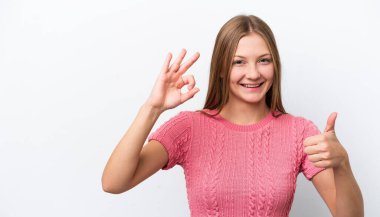 Beyaz arka planda izole edilmiş genç bir Rus kadın işaret ve baş parmak işareti gösteriyor.