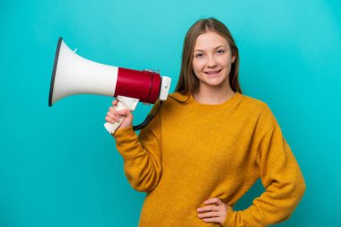 Mavi arka planda izole edilmiş genç bir Rus kadın elinde bir megafon ve gülümsüyor.