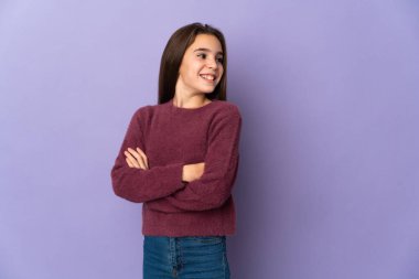 Mor arka planda izole edilmiş, kolları bağlı ve mutlu küçük bir kız.