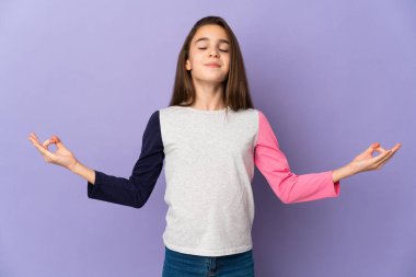 Mor arka planda izole edilmiş küçük bir kız Zen pozunda