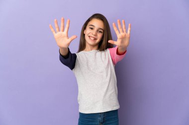 Mor arka planda izole edilmiş küçük kız parmaklarıyla ona kadar sayıyor.