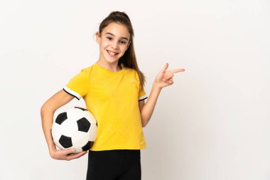 Küçük futbolcu kız beyaz arka planda izole edilmiş, parmağını yana doğru gösteriyor.