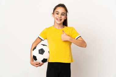Beyaz arka planda izole edilmiş küçük futbolcu kız başparmak hareketi yapıyor.