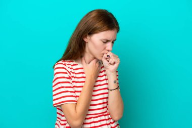 Mavi arka planda izole edilmiş genç İngiliz kadın çok öksürüyor.