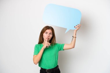 Beyaz arka planda izole edilmiş genç bir İngiliz kadın boş bir konuşma balonu tutuyor ve sessiz jest yapıyor.