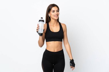 Spor su şişesiyle beyaz arka planda izole edilmiş genç bir kadın.