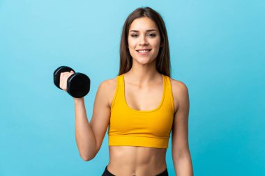 Beyaz kadın halter yapıyor. Mavi arka planda izole edilmiş.