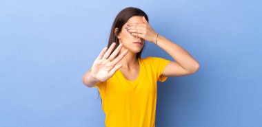 İzole edilmiş geçmişi olan beyaz bir kadın jesti durdurup yüzünü kapatıyor.