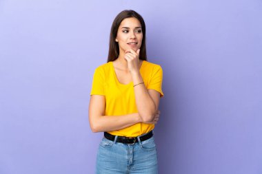 Kafkasyalı genç bir kadın soyutlanmış arka planda, yana bakıyor ve gülümsüyor.