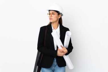 Miğferli, beyaz, genç bir kadın. Arka planda izole edilmiş planlar tutuyor.