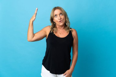 Orta yaşlı sarışın bir kadın, izole edilmiş, yorgun ve hasta bir yüzü var.