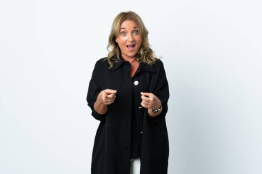 Orta yaşlı sarışın kadın soyutlanmış beyaz arka planda ön tarafı gösteriyor ve gülümsüyor.