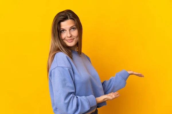 Young Slovak Woman Isolated Yellow Background Extending Hands Side Inviting — 图库照片