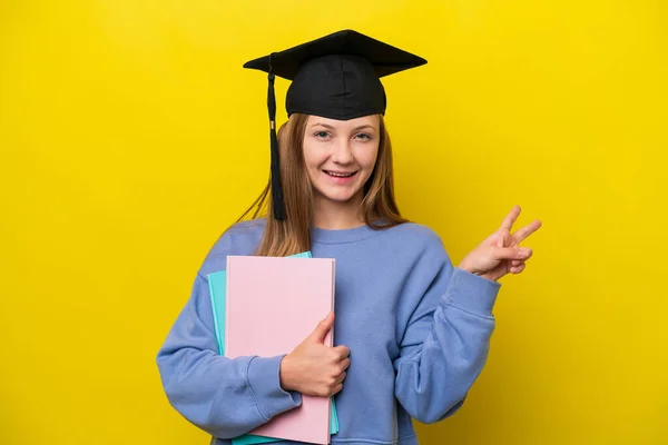 Νεαρή Μαθήτρια Ρωσίδα Απομονωμένη Κίτρινο Φόντο Χαμογελώντας Και Δείχνοντας Σύμβολο — Φωτογραφία Αρχείου
