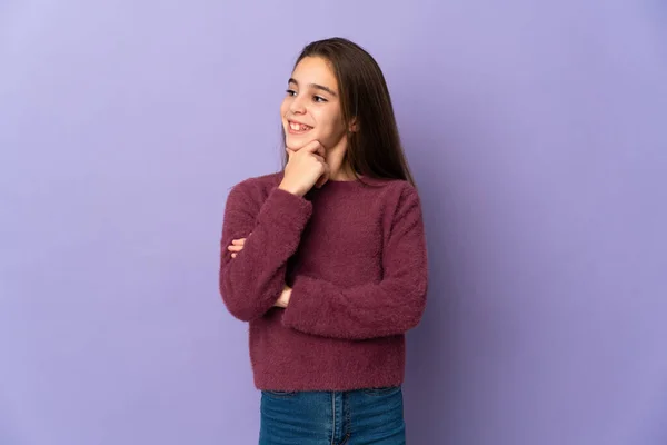 Klein Meisje Geïsoleerd Paarse Achtergrond Kijken Naar Zijkant Glimlachen — Stockfoto