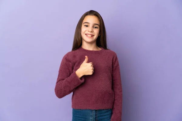 紫色の背景に孤立した少女親指を上げるジェスチャー — ストック写真