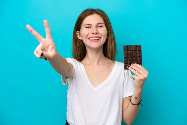 Mladá Anglická Žena Čokoládou Izolované Modrém Pozadí Úsměvem Ukazující Vítězství — Stock fotografie