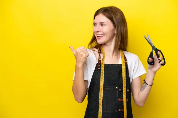Young Seamstress English Woman Isolated Yellow Background Pointing Side Present — Stockfoto
