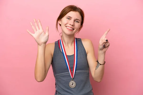 Joven Mujer Inglesa Con Medallas Aisladas Sobre Fondo Rosa Contando —  Fotos de Stock