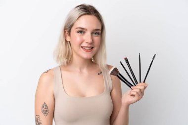 Beyaz arka planda izole edilmiş beyaz bir kadın elinde makyaj fırçası tutuyor.