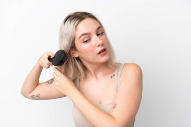 Beyaz arka planda saç tarağıyla izole edilmiş beyaz bir beyaz kadın.