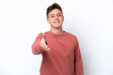 Beyaz arka planda izole edilmiş yakışıklı Brezilyalı adam iyi bir anlaşma için el sıkışıyor.