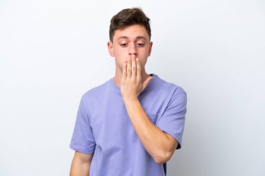 Genç, yakışıklı Brezilyalı bir adam beyaz arka planda izole edilmiş, ağzı elle kapatılmış.