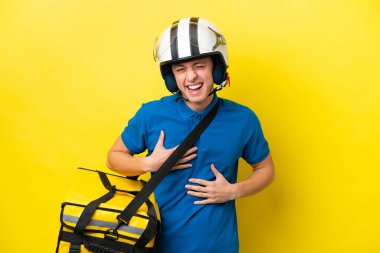 Termal sırt çantalı genç Brezilyalı adam sarı arka planda izole edilmiş, gülümsüyor.