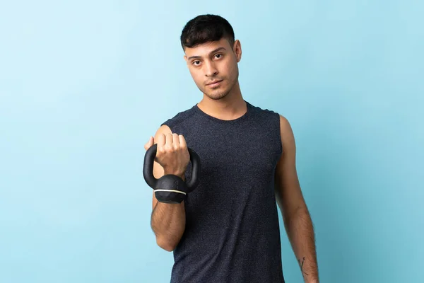 Young Colombian Man Isolated Blue Background Making Weightlifting Kettlebell — Stock Photo, Image