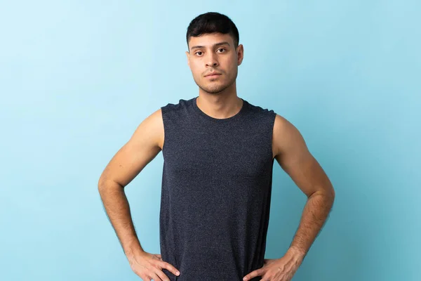 Young Colombian Man Isolated Blue Background Posing Arms Hip — Stock Photo, Image