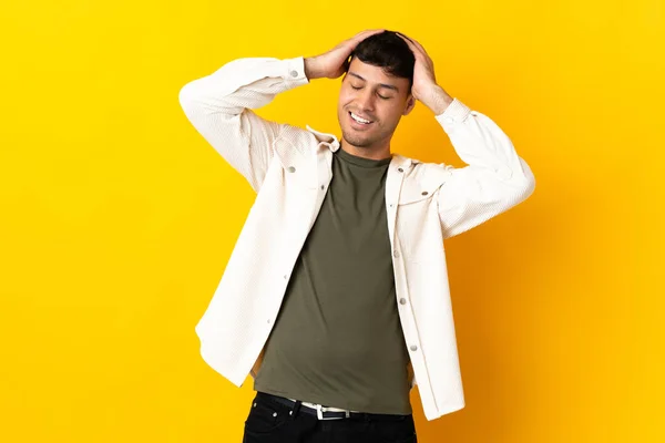 若いコロンビア人男性は黄色の背景に笑って隔離された — ストック写真