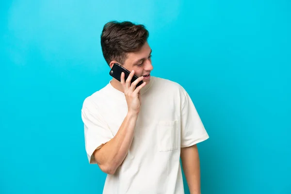 Młody Przystojny Brazylijczyk Odizolowany Niebieskim Tle Prowadzenie Rozmowy Telefon Komórkowy — Zdjęcie stockowe