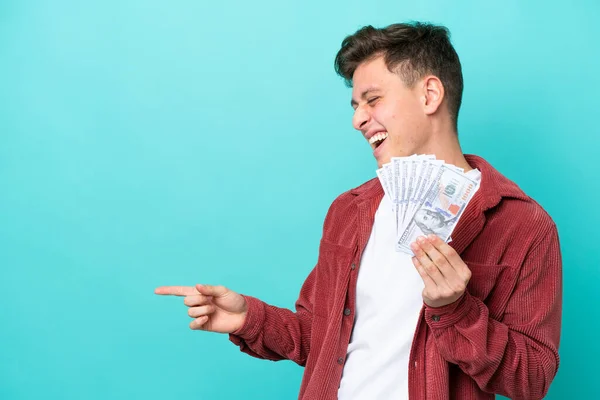 Young Brazilian Man Taking Lot Money Isolated Blue Background Pointing — стоковое фото