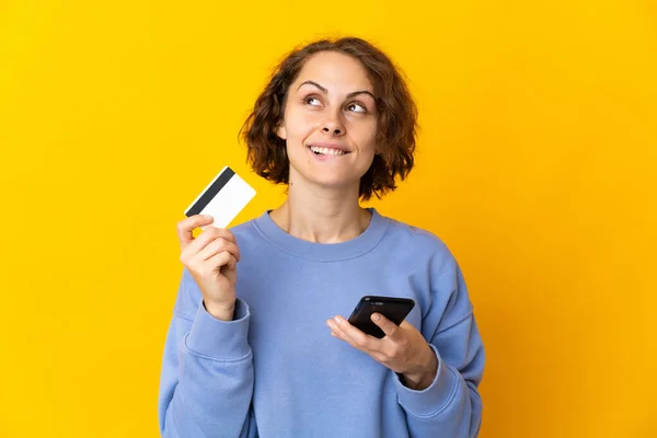 Młoda Angielka Odizolowana Różowym Tle Kupuje Pomocą Telefonu Komórkowego Kartą — Zdjęcie stockowe