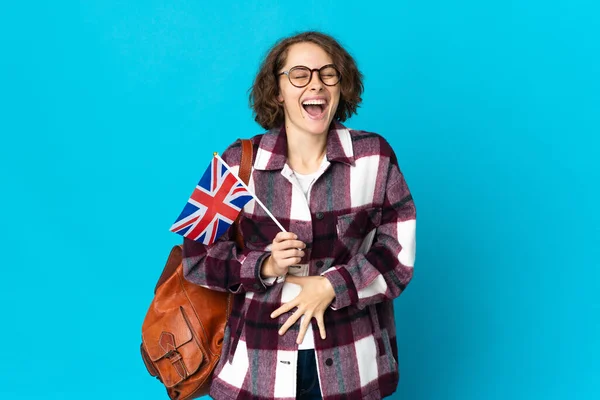 Молодая Английская Женщина Держащая Флаг Великобритании Изолированы Синем Фоне Улыбаясь — стоковое фото