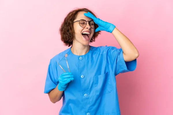 英国女牙医带着工具 在粉色背景下被隔离 面带微笑 — 图库照片