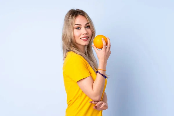 Έφηβη Ρωσίδα Που Κρατάει Ένα Πορτοκάλι Απομονωμένο Μπλε Φόντο — Φωτογραφία Αρχείου