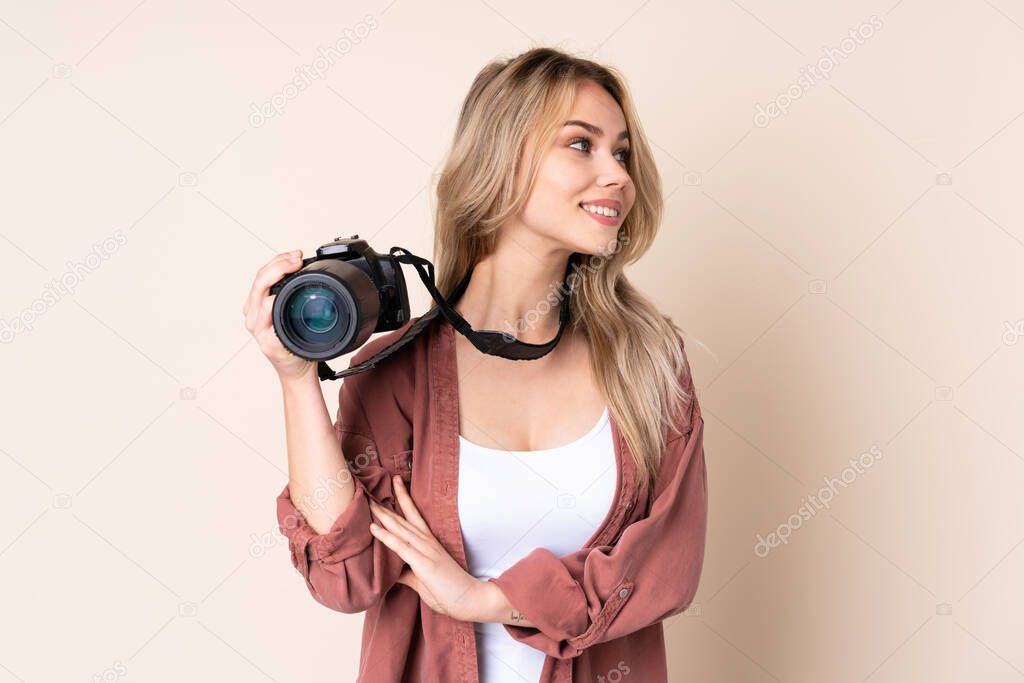 Young photographer girl over isolated background looking side