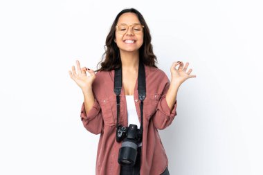 Zen pozunda, izole edilmiş beyaz arka planı olan genç fotoğrafçı kadın.