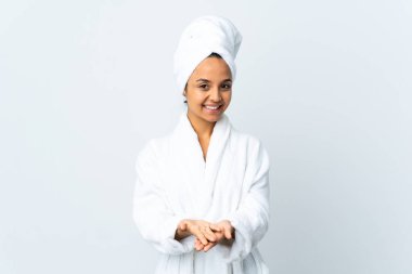 Bornozlu genç bir kadın izole edilmiş beyaz arka plan üzerinde bir ilan vermek için fotokopi makinesi tutuyor.