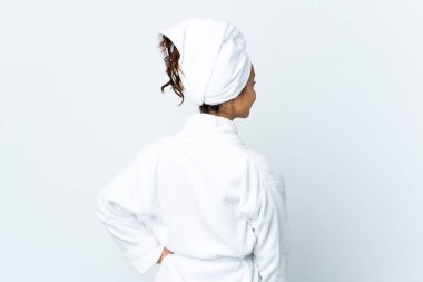 Young woman in bathrobe over isolated white background in back position and looking side