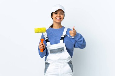 Painter woman over isolated white background holding copyspace imaginary on the palm to insert an ad and with thumbs up